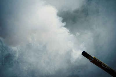 Low angle view of smoke emitting from chimney against sky