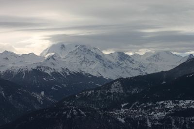 Scenic view of mountains against cloudy sky