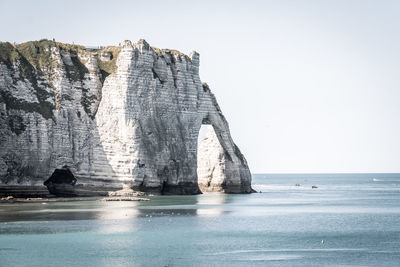 Rock formations in sea against clear sky