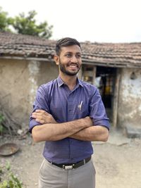 Portrait of young man standing against wall