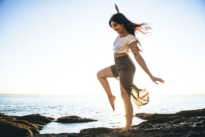 Full length of woman on beach against clear sky