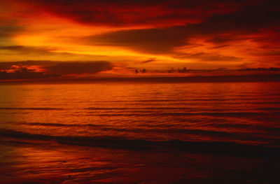 Scenic view of sea against dramatic sky during sunset