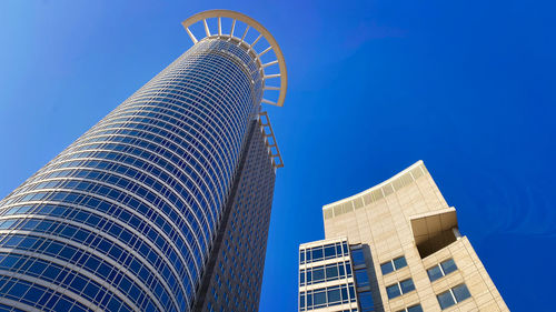 Low angle view of modern building against blue sky