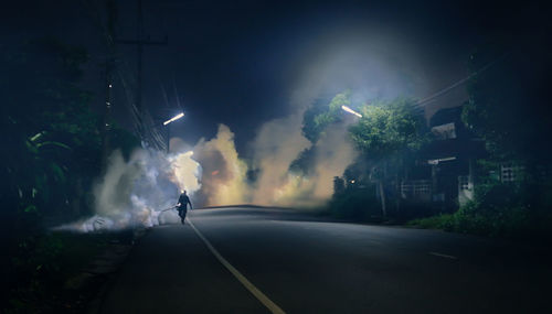 Rear view of man riding motorcycle on road