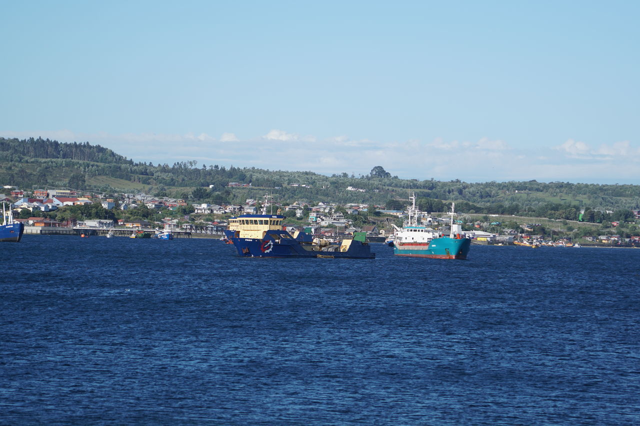 SEA BY BUILDINGS AGAINST SKY