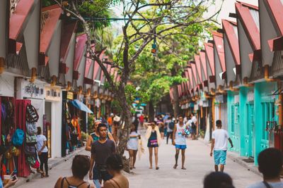 People on street amidst buildings in city