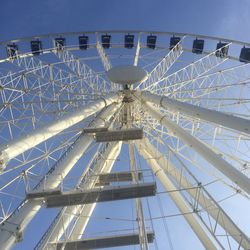 Low angle view of ferris wheel against blue sky