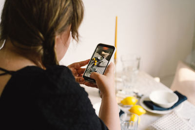 Video blog. a young woman is filming kitchen goods for her online store on her phone camera.