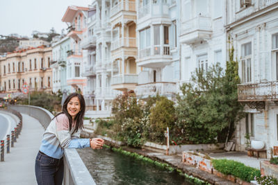 Portrait of young woman standing in city