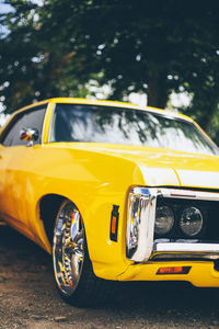 Close-up of yellow car on road