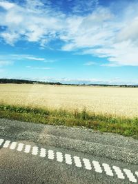 Scenic view of field against cloudy sky