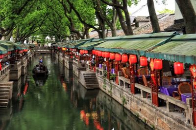 View of boats in canal along trees