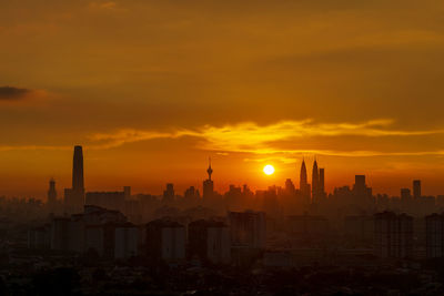 Modern buildings against sky during sunset