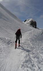 Rear view of person skiing on snow against sky