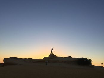 Silhouette of statue against clear sky during sunset
