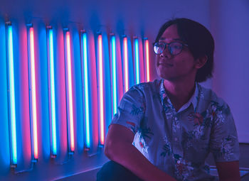 Portrait of young man on a neon light room