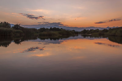 Scenic view of calm lake at sunset