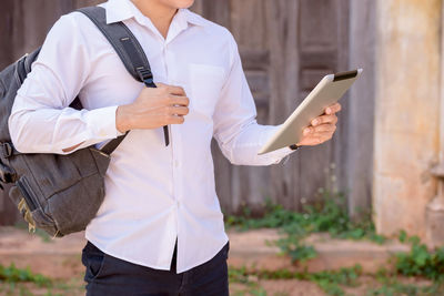 Midsection of man holding mobile phone