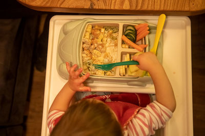 Rear view of girl eating food