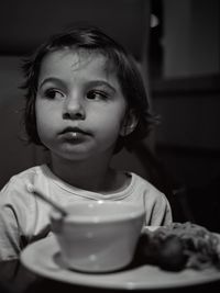 Close-up of girl looking away while food in plate on table