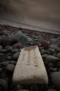 Close-up of stones on beach against sky