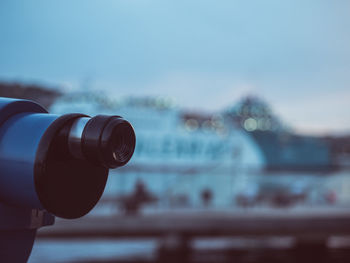 Close-up of coin-operated binoculars in city at dusk