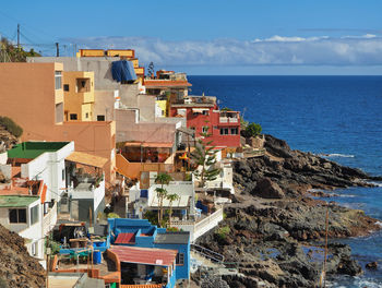 High angle view of townscape by sea against sky