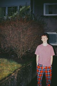 Portrait of teenage girl standing against built structure