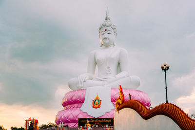 Low angle view of buddha statue against sky