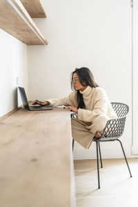 Young freelancer working on laptop at desk in home office