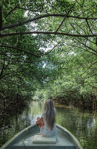 Rear view of woman sitting in water