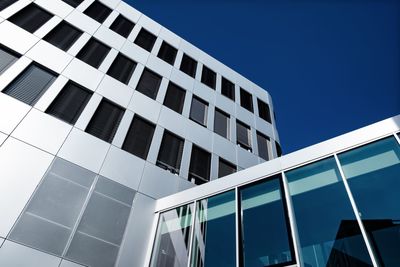 Low angle view of modern building against clear blue sky