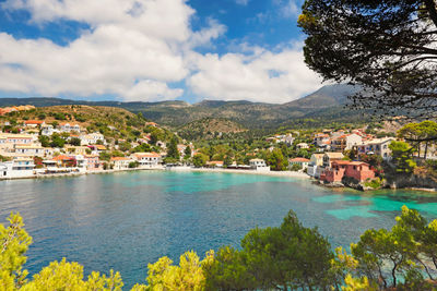 Scenic view of townscape by sea against sky