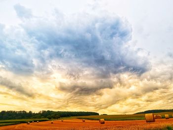 Hay bales on field against sky