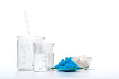 Close-up of ice cream in glass jar on table against white background