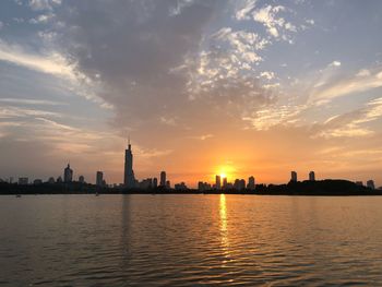 City buildings at waterfront during sunset