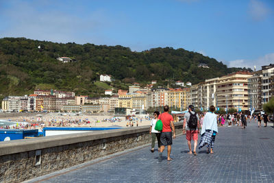 People walking on mountain against sky in city