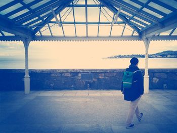 Full length of woman standing on bed