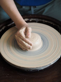 Woman starts to create a ceramic cup on the pottery wheel. working with clay on potter's wheel.