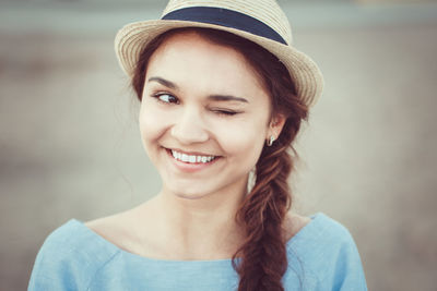 Close-up of smiling woman looking away while winking