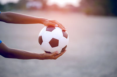 Cropped hand holding sports ball 