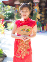 Portrait of smiling girl standing against tree