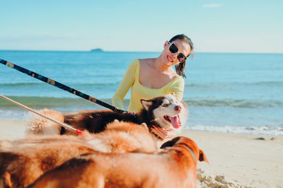 Portrait of woman with dog on beach