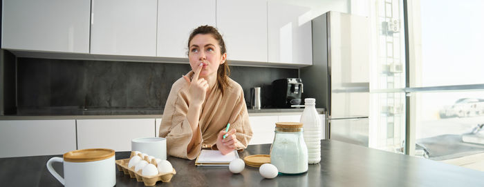 Portrait of young woman using mobile phone at home