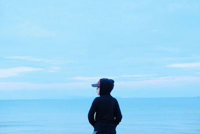 Rear view of man looking at sea against sky