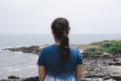 Rear view of woman looking at sea against sky