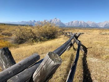 Wooden fence on field against sky teton range 