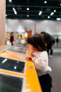 Cute girl looking at illuminated game