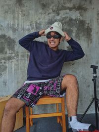 Frustrated man sitting on chair against wall