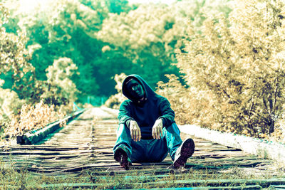 Side view of man sitting on grassland